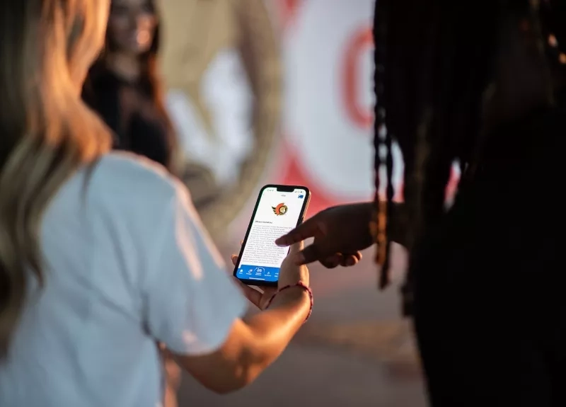 Two people using the CAA Mobile App to browse savings Two people using the CAA Mobile App to browse savings